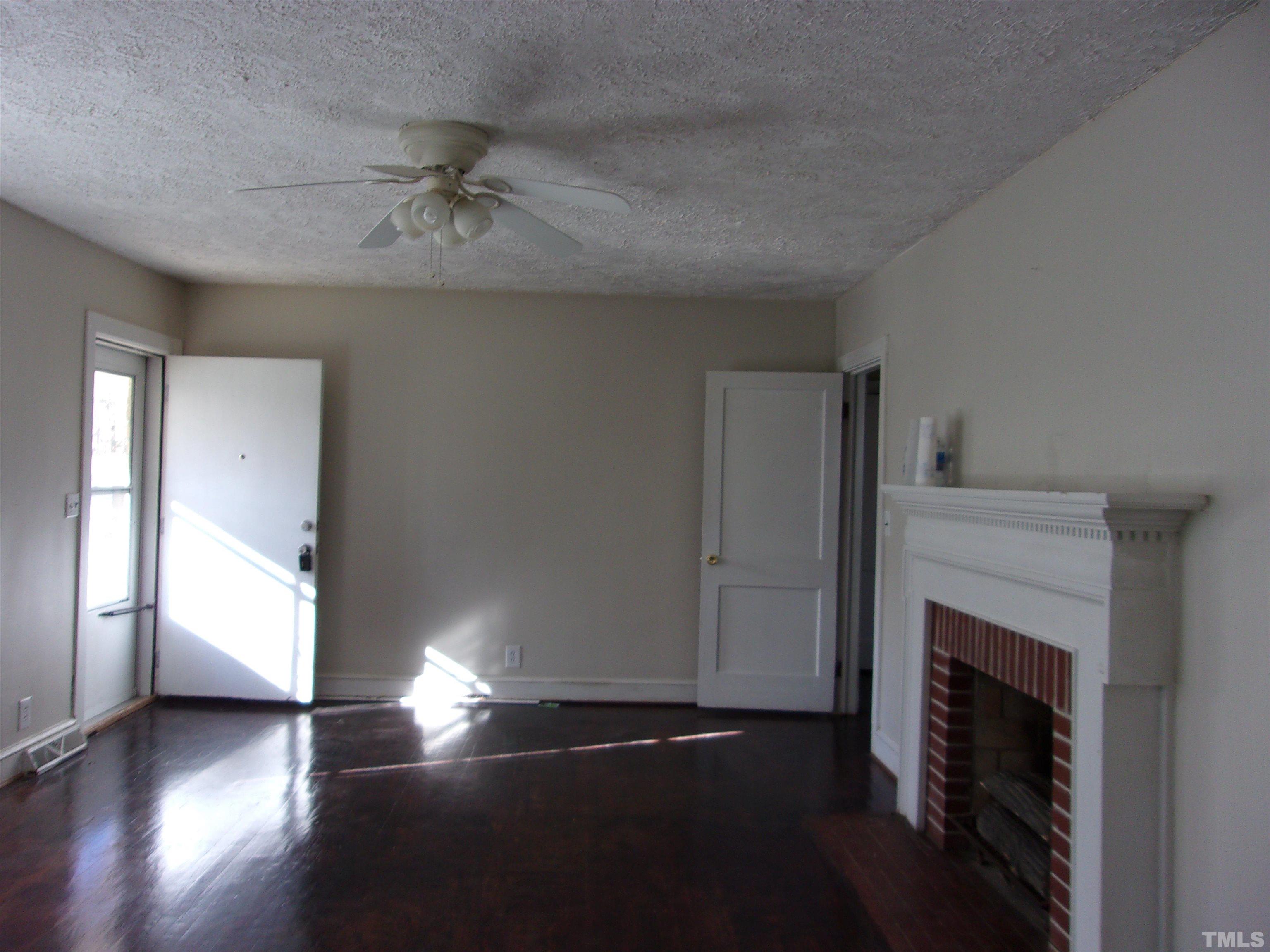 132 Trotter Street Roxboro, NC 27573 - Photo 3 of 12 a view of empty room with wooden floor and fan