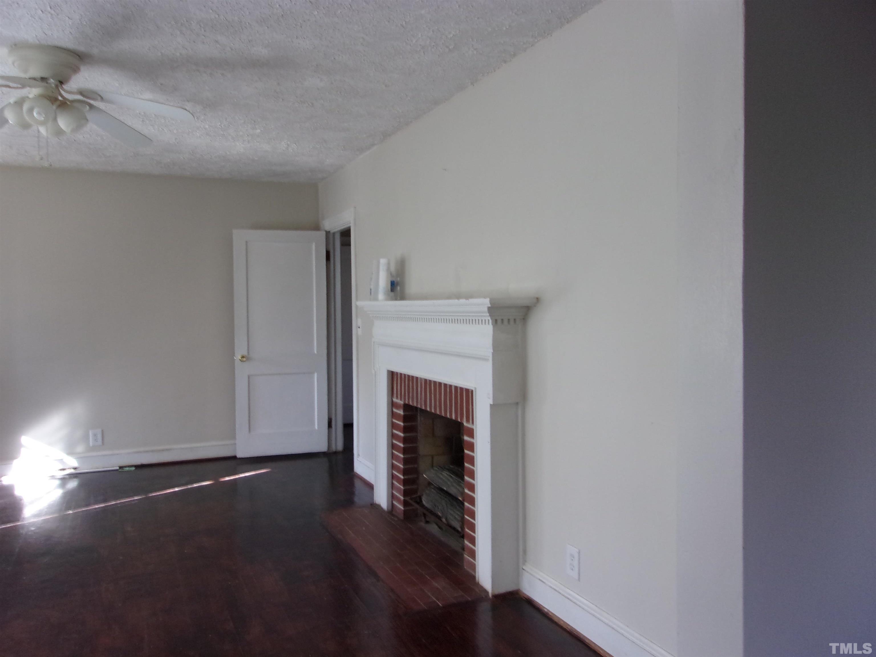 132 Trotter Street Roxboro, NC 27573 - Photo 4 of 12 a view of a livingroom with wooden floor and a fireplace