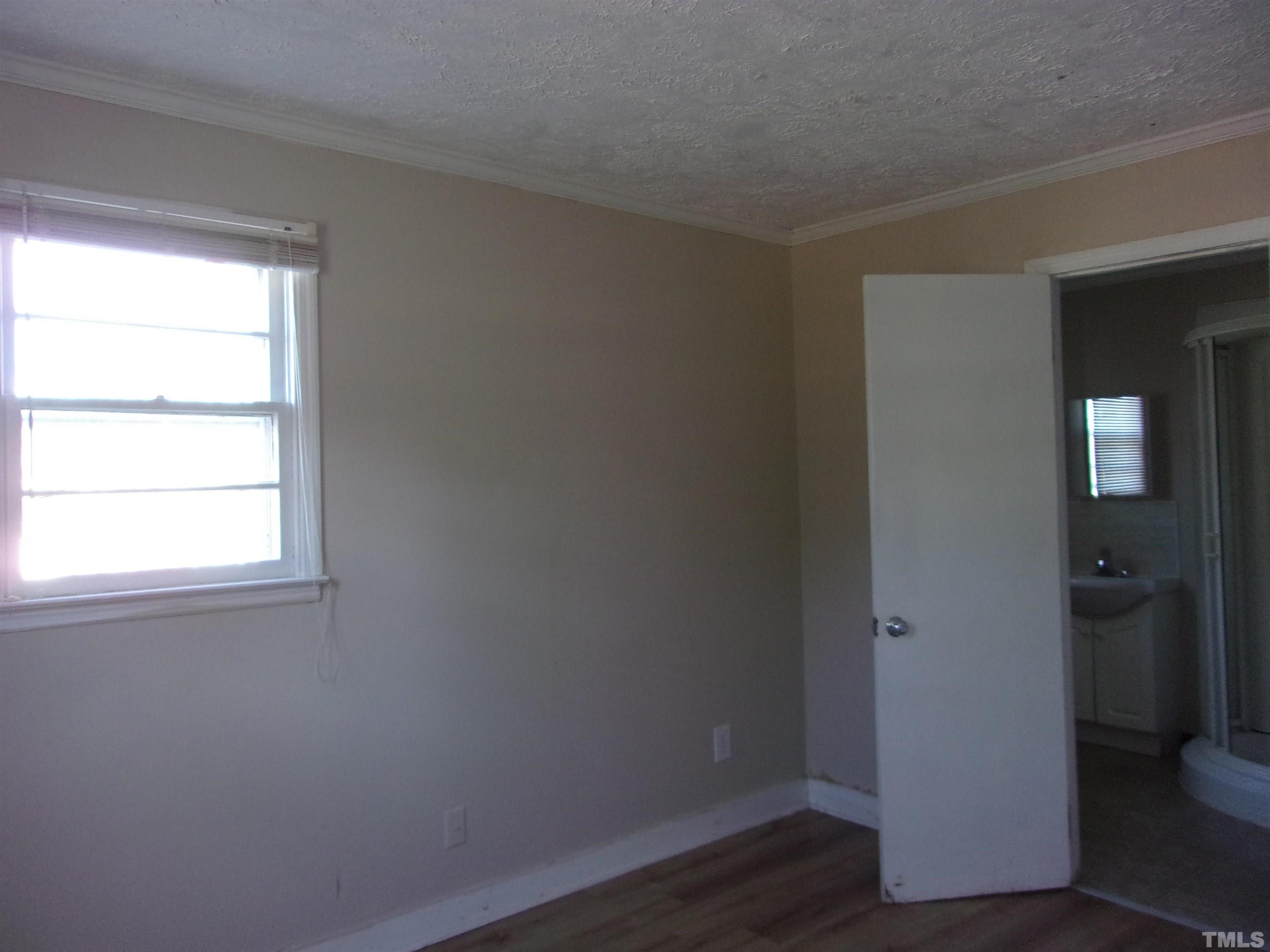 132 Trotter Street Roxboro, NC 27573 - Photo 8 of 12 an empty room with wooden floor and a window