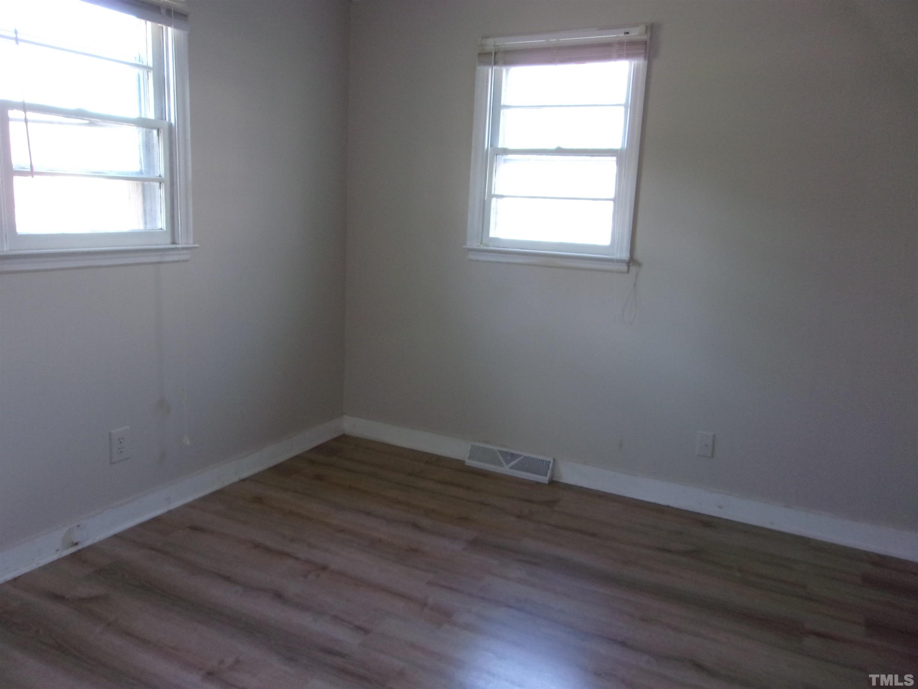 132 Trotter Street Roxboro, NC 27573 - Photo 9 of 12 an empty room with wooden floor and windows