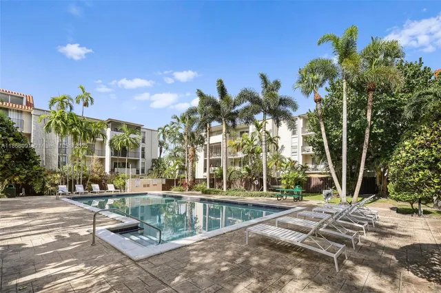 a view of a fountain in the yard with palm trees
