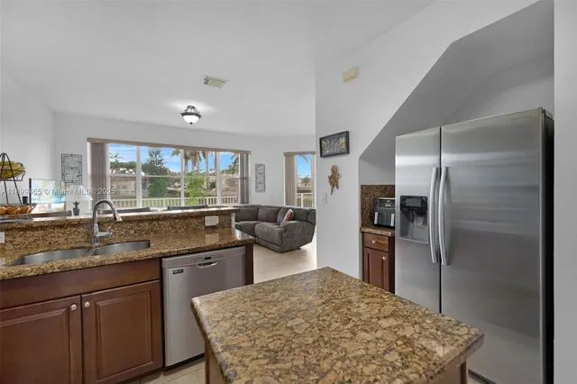 a kitchen with a refrigerator cabinets and wooden floor