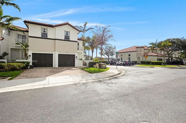 a view of a white house with a yard and garage