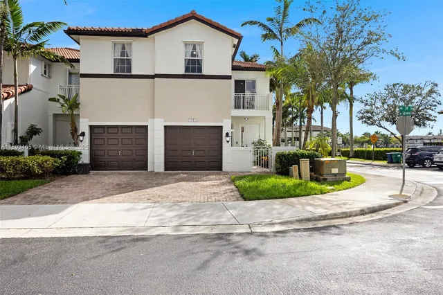 a front view of a house with a yard and potted plants
