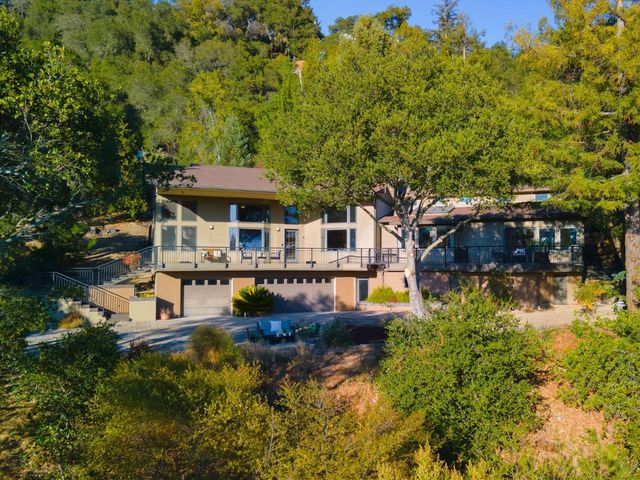 a view of a patio with couches table and chairs under an umbrella