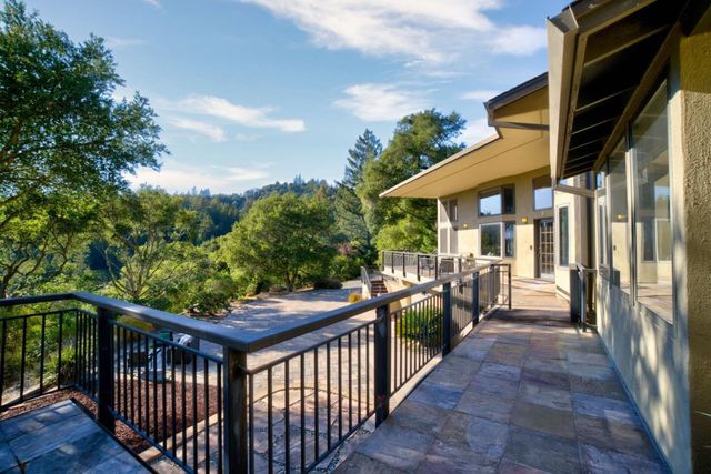 a view of a balcony with couple of couches and wooden fence