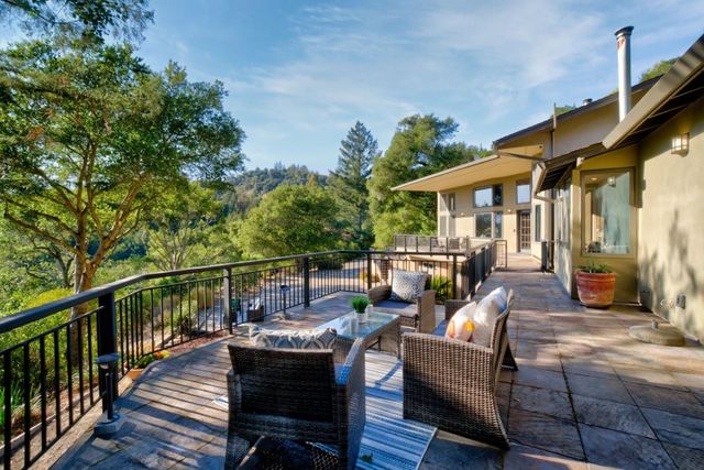 a dining room with furniture large windows and a chandelier