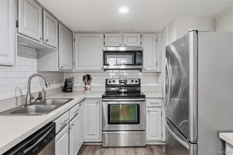a kitchen with stainless steel appliances a stove a sink and cabinets