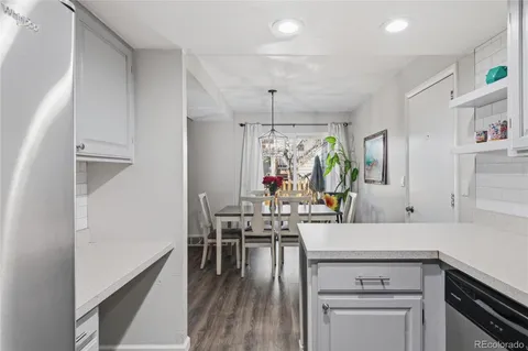 a kitchen with a table chairs refrigerator and cabinets