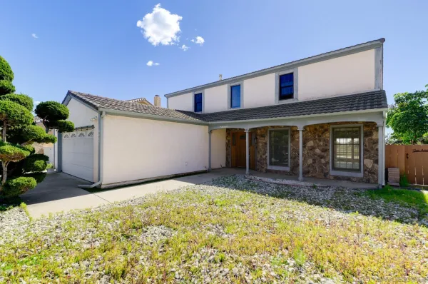 a view of a house with a yard and potted plants