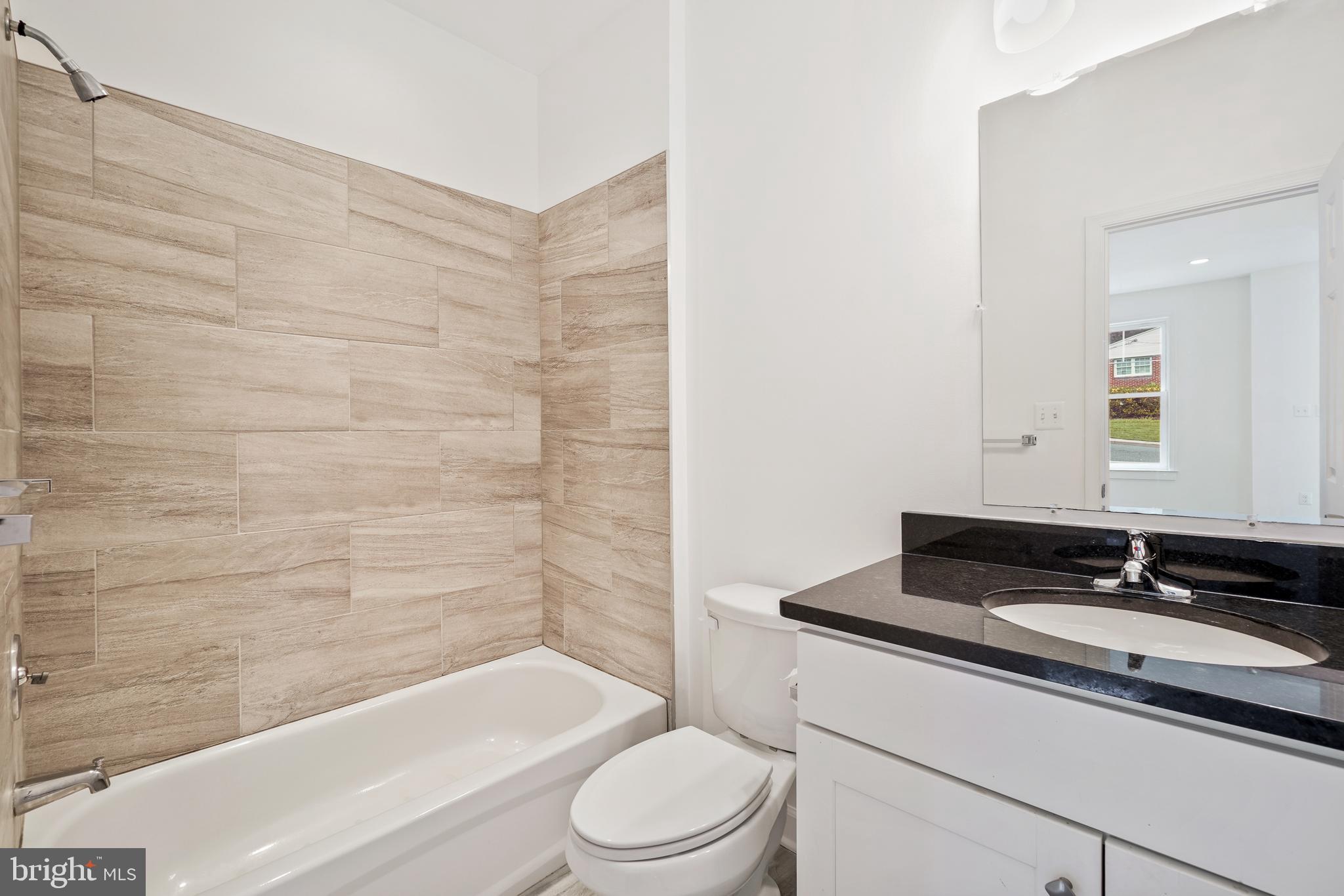 3114 19th Street South Arlington, VA 22204 - Photo 17 of 31 a bathroom with a granite countertop sink toilet a mirror and bathtub