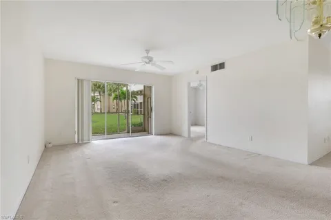 a view of a big room with windows and chandelier fan