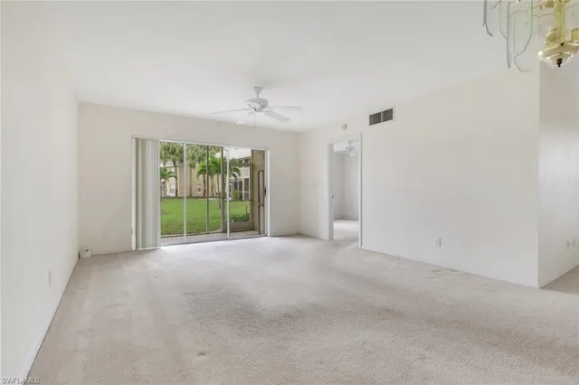 a view of a big room with windows and chandelier fan