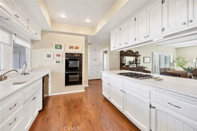 a large kitchen with stainless steel appliances granite countertop a stove and a white cabinets
