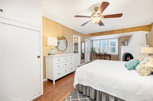a bed room with a bed a dresser and potted plants
