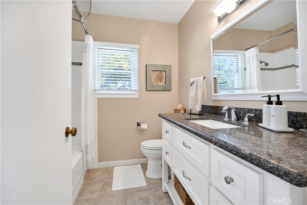 27454 Hemet Street Hemet, CA 92544 - Photo 34 of 51 a bathroom with a granite countertop sink a toilet and a window