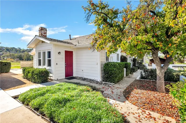 a view of a house with a small yard and potted plants