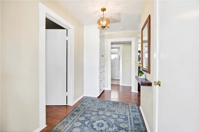 view of a hallway with wooden floor and a bathroom