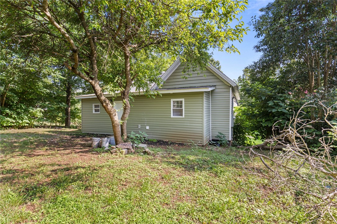 109 Farmer Street Anderson, SC 29621 - Photo 6 of 31 A verdant backyard retreat surrounds this charming outbuilding with mature trees and natural landscaping.