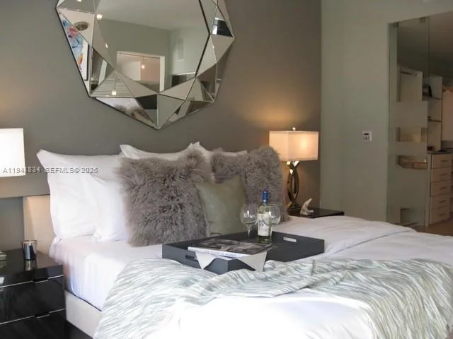a large bed sitting in a bedroom next to a chandelier