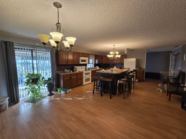 a living room with furniture a chandelier and a dining table