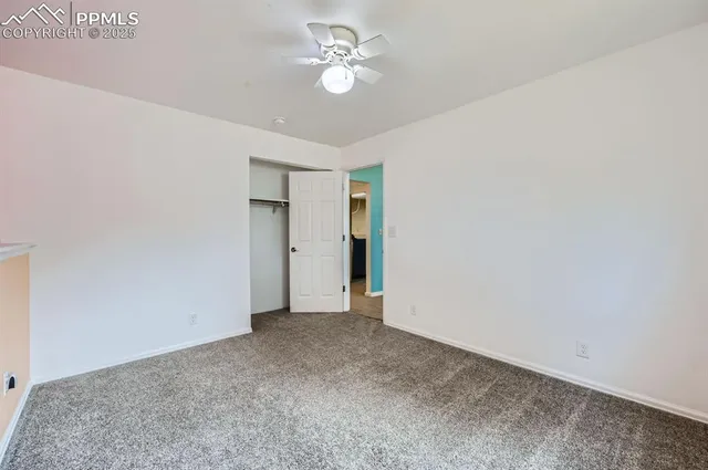 a view of an empty room with a ceiling fan