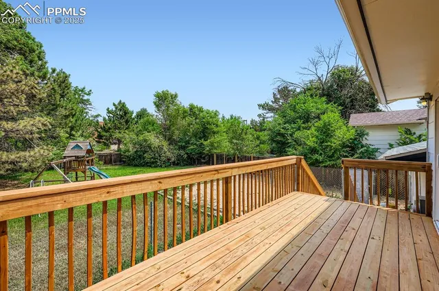 a balcony with wooden floor and fence