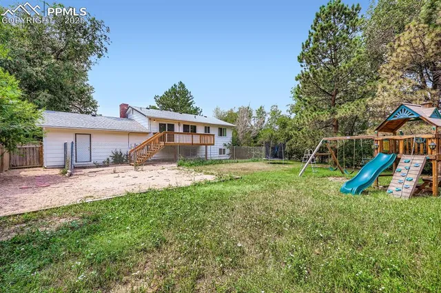 a view of a house with a backyard and a slide