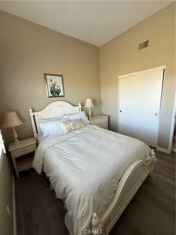 a bedroom with bed and wooden floor
