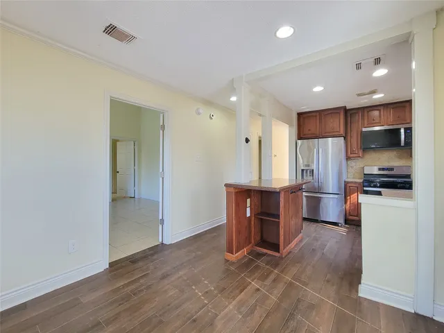 a kitchen with stainless steel appliances granite countertop a refrigerator and a stove top oven