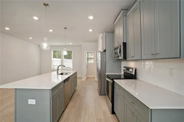 a large kitchen with stainless steel appliances lots of counter space and wooden floor