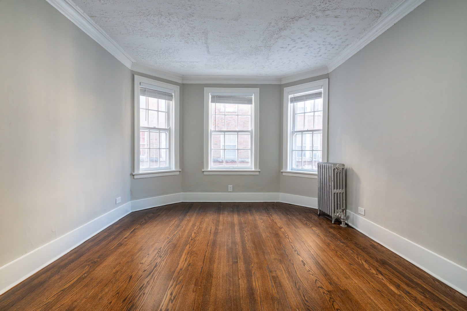 7420 North Damen Avenue, Unit 1F Chicago, IL 60645 - Photo 15 of 18 an empty room with wooden floor and windows