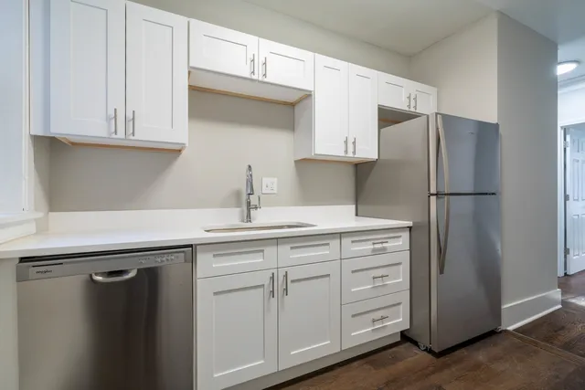 a kitchen with white cabinets and refrigerator