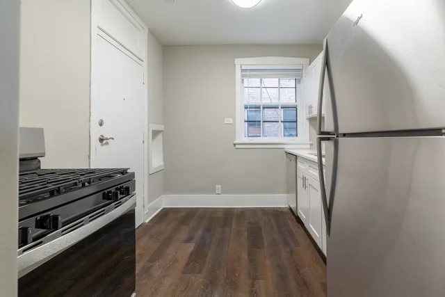 a view of a room with wooden floor and electronic appliances