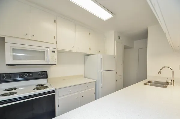 a kitchen with a stove and white cabinets