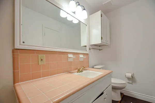 a bathroom with a sink a toilet and mirror