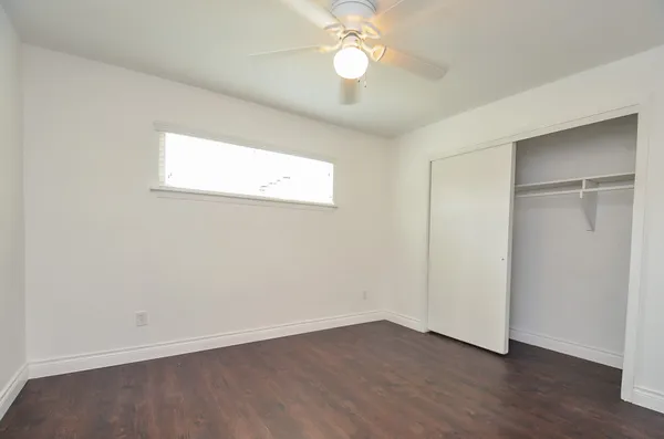 a view of an empty room with wooden floor