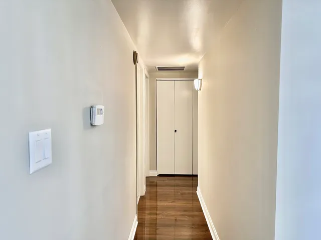 a view of a hallway with wooden floor