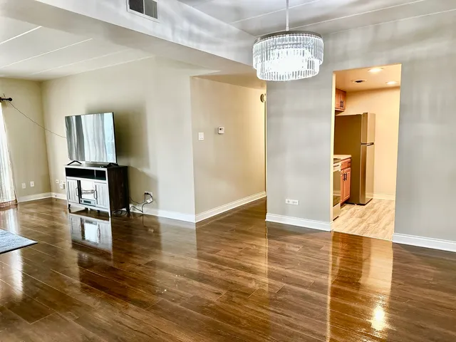 a view of empty room with wooden floor