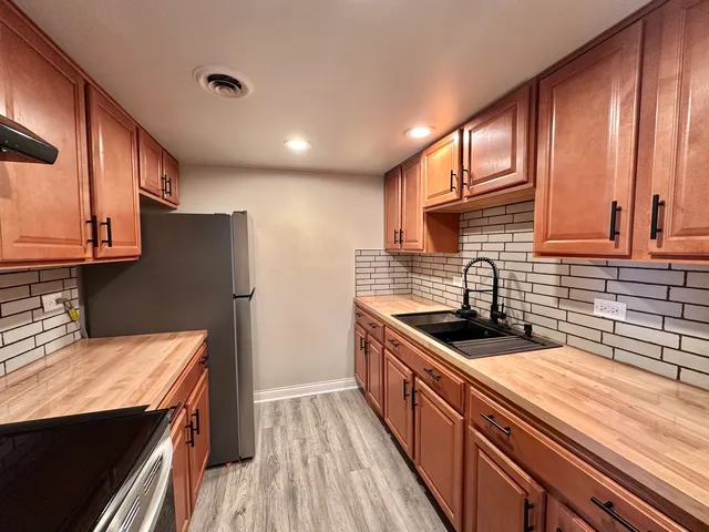 a kitchen with stainless steel appliances granite countertop a sink stove and refrigerator