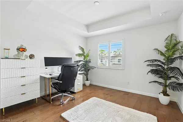 a view of a workspace with furniture and a window