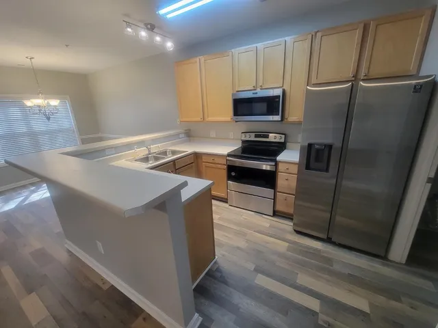 a kitchen with stainless steel appliances a refrigerator a stove a microwave and cabinets