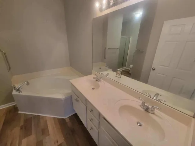 a bathroom with a tub sink and mirror