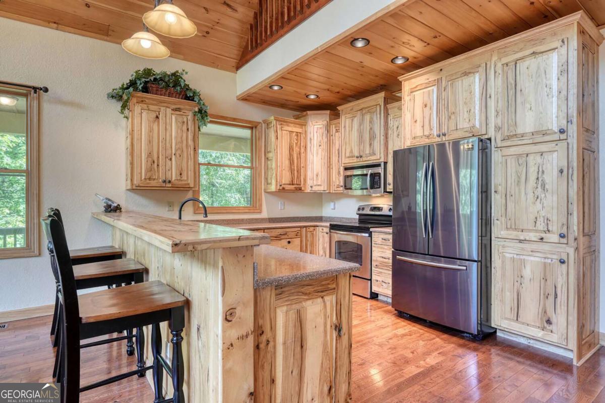 235 Oak Rdg Estate Murphy, NC 28906 - Photo 18 of 54 a kitchen with stainless steel appliances granite countertop a refrigerator a sink dishwasher a stove a dining table and chairs with wooden floor