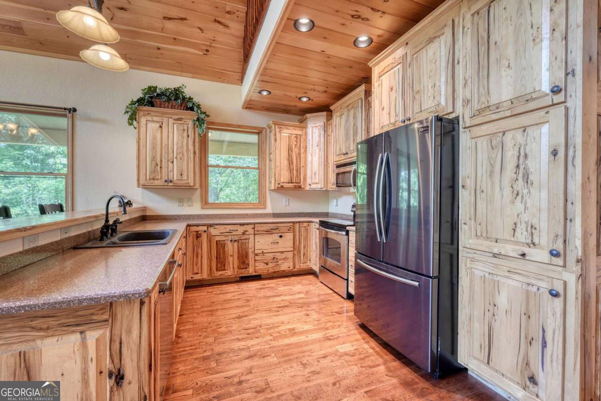 235 Oak Rdg Estate Murphy, NC 28906 - Photo 21 of 54 a kitchen with granite countertop a refrigerator a sink dishwasher stove and refrigerator with wooden floor