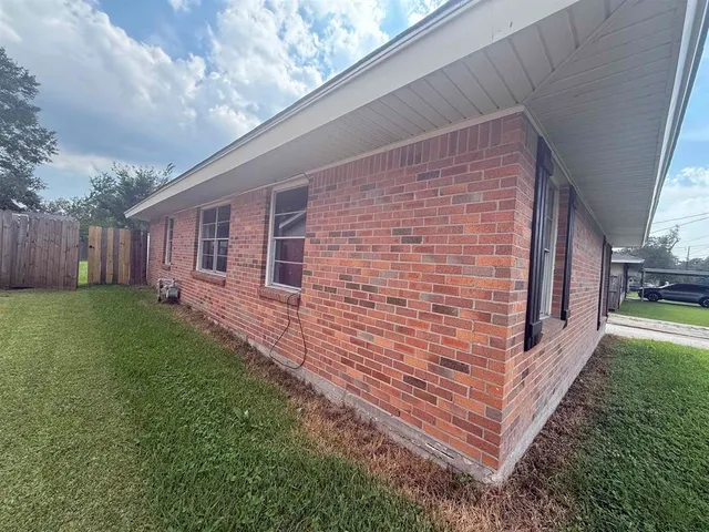 a view of backyard with barbeque grill and wooden fence