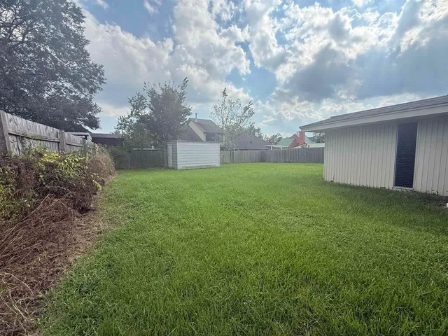 a backyard of a house with lots of green space and plants