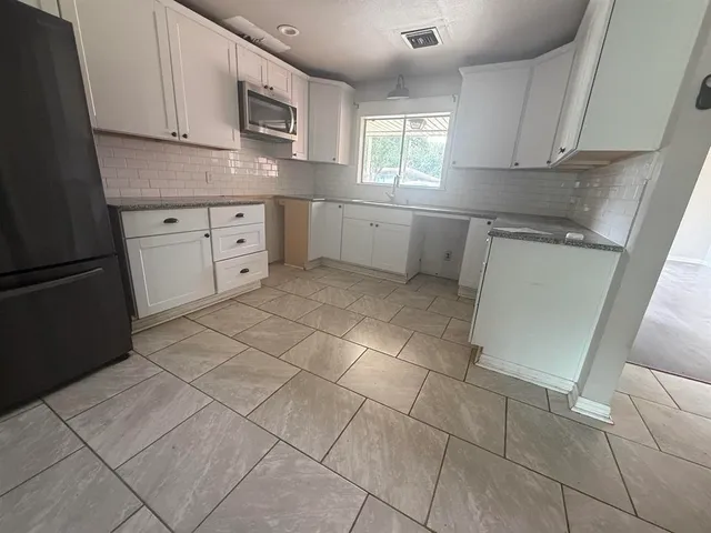 a kitchen with stainless steel appliances a sink stove and cabinets
