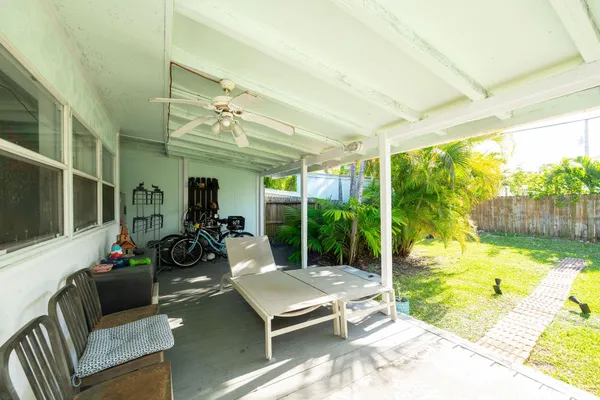 a living room with patio furniture and a floor to ceiling window