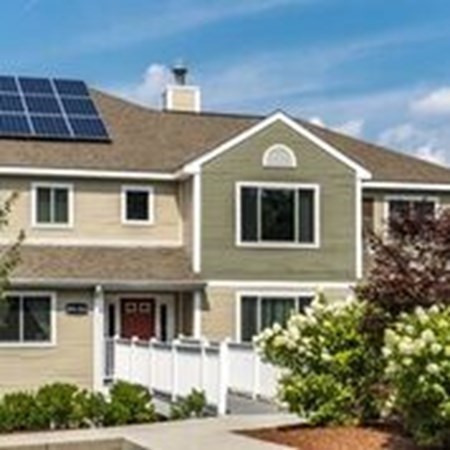 a front view of a house with garage and plants